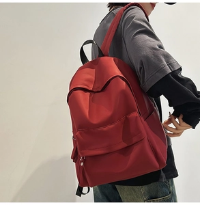 Detail view of the deep red large capacity backpack showing functional side pocket and straps
