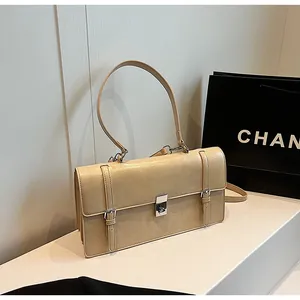 Detailed view of silver twist lock and decorative vertical buckle straps on beige handbag