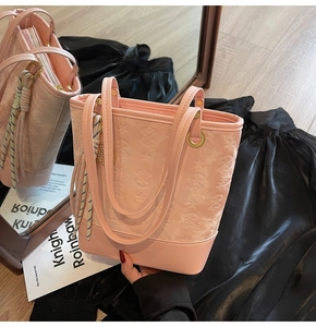 Macro detail of pink tote bag showing star embossed texture and golden hardware