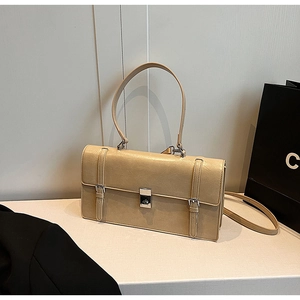 Detail of beige rectangular leather shoulder bag featuring silver buckle and dual straps