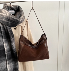 Close-up of vintage brown tote bag with suede and smooth leather texture with metal twist lock