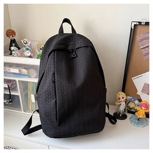 Detail of black backpack featuring a unique vertical knit texture and hidden zipper pocket