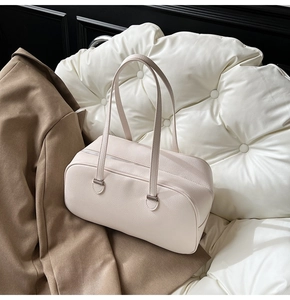 Detailed view of beige pebble leather shoulder bag with silver hardware and smooth zipper