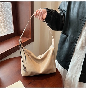 Détail du sac hobo en similicuir beige avec pendentif cœur et intérieur spacieux et chic