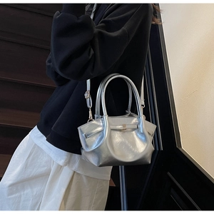 Dettaglio della borsa tote argento metallizzato con doppi manici e tracolla regolabile