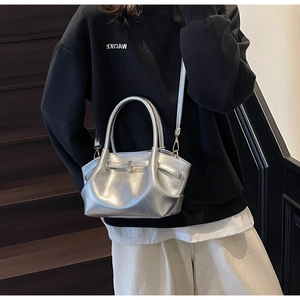 Dettaglio della borsa tote argento metallizzato con texture plissettata e tracolla