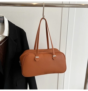 Detail of caramel leather shoulder bag with lychee texture and silver zipper hardware