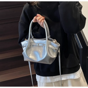 Dettaglio della borsa tote argento metallizzato con trama stropicciata e fibbia decorativa