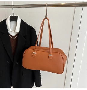 Close-up of caramel pebbled leather shoulder bag hanging with stylish casual outfits