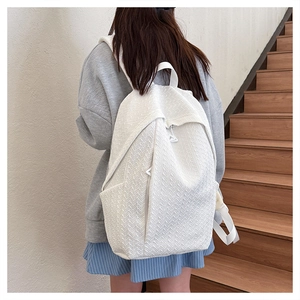 Detail of white backpack featuring premium chevron woven texture and front zipper pocket