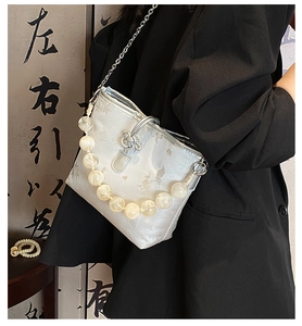 Détail du sac en satin jacquard avec fermeture chinoise et poignée en perles