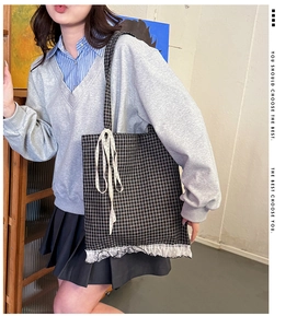 Plaid canvas tote bag with white lace trim and ribbon detail shown on a model