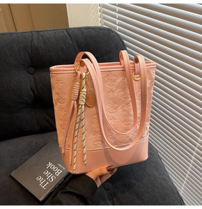Detailed view of pink tote bag with star patterns and tennis racket charm detail