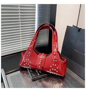 Gedetailleerd zicht op de rode laklederen tas met glanzende zilveren metalen klinknagels