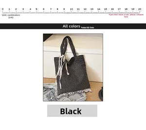 Close-up of black and white checkered canvas tote bag with lace trim and bow detail