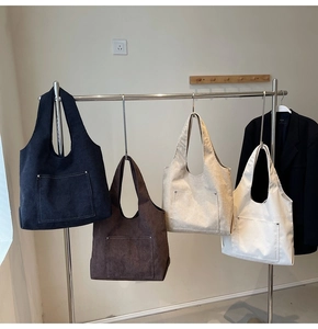 Detailed close-up of corduroy tote bags in four colors with front pockets and rivets