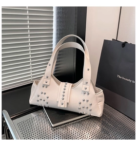 Detail van de crème punk schoudertas met zilveren studs en matte lederen textuur