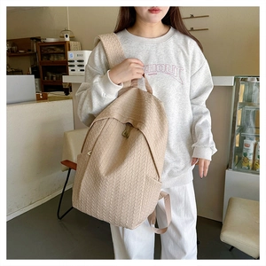 Detail of beige backpack with woven texture and premium metal zipper on shoulder strap