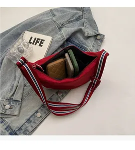 Detail view of red crescent bag interior showing large capacity and striped strap