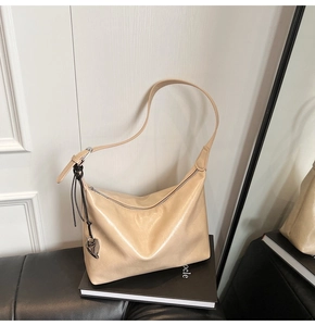 Détail du sac hobo doré champagne avec pendentif cœur argenté et fermeture éclair fluide