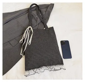 Close-up of black and white checkered tote bag with lace trim showing large capacity size