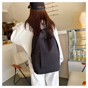 Close-up of black backpack featuring high-quality woven texture and waterproof fabric detail