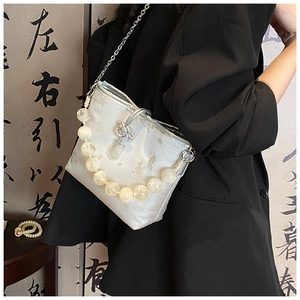 Détail du sac jacquard argenté avec poignée en perles et nœud chinois en argent