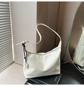 Détail du sac cabas en simili cuir crème avec pendentif cœur et fermeture zippée
