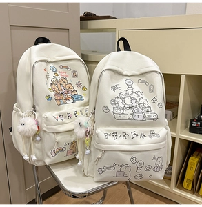 Close-up of white canvas backpacks featuring cute cartoon Capybara prints and plush charms