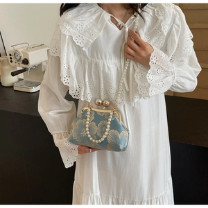 Detail of blue Chinese style embroidered clutch with gold flowers and pearl strap