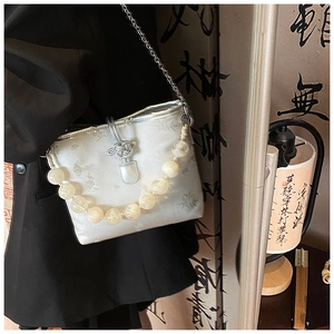 Détail du sac à main en brocart argenté avec poignée en perles et boucle en métal