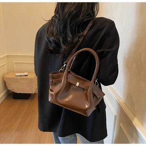 Vista dettagliata della borsa tote in pelle marrone scuro con fibbie e tracolla regolabile