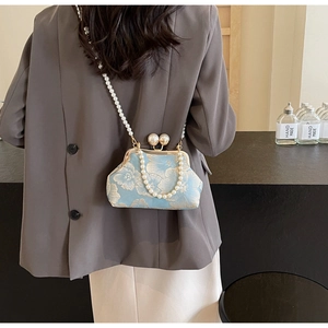 Detail of light blue floral embroidery bag with vintage pearl strap and clasp