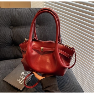 Dettaglio della borsa tote in pelle rossa con fibbia in metallo e tracolla rimovibile