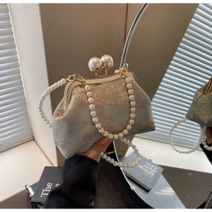 Detail of floral embroidery on light green evening bag with pearl clasp and chain