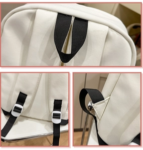 Close-up of white canvas backpack showing adjustable straps and reinforced stitching