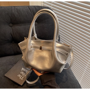 Dettaglio della borsa tote argento metallizzato con fibbia dorata e finitura testurizzata