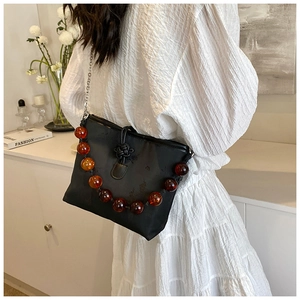 Vue détaillée du sac seau noir plissé avec perles ambrées et fermoir traditionnel chinois