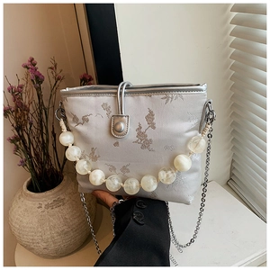 Détail du sac en brocart gris argenté avec broderie fleur de prunier et anse perlée