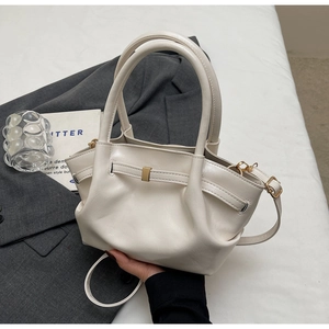 Dettaglio di una borsa tote in pelle PU color crema con fibbia in metallo e tracolla regolabile