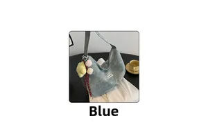 Blue denim hobo bag featuring a cute plush chick keychain on a minimalist desk setup