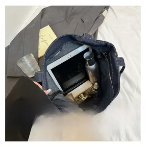 Macro top view of large denim tote bag interior showing capacity for tablets and cosmetics