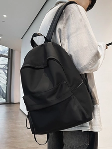 Minimalist black waterproof nylon backpack for students and urban commuting with wide straps