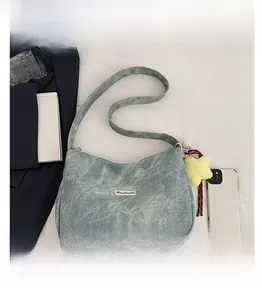 Detail view of light blue denim hobo bag with yellow star charm in a lifestyle setting
