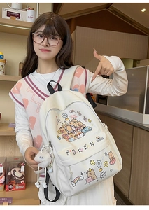 Close-up of white PU leather backpack with cartoon Capybara print and plush monster charm