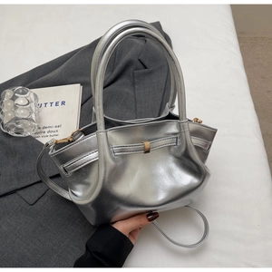 Dettaglio della borsa tote argento metallizzato con doppi manici e fibbia dorata
