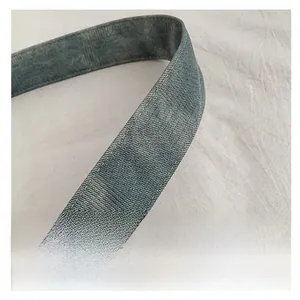 Close-up of durable washed denim blue shoulder strap with white double stitching