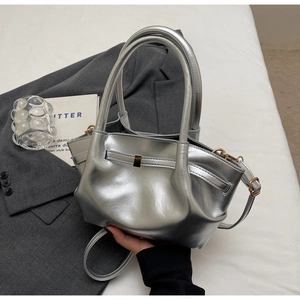 Dettaglio borsa metallizzata argento con fibbia dorata e pelle effetto specchio