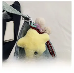 Detail of yellow star faux fur charm with colorful acrylic chain on a denim shoulder bag
