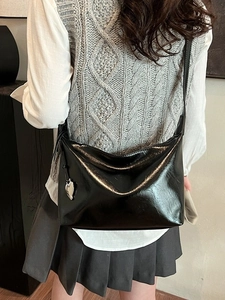 Sac fourre-tout noir brillant avec breloque cœur argentée vu de dos avec élégance